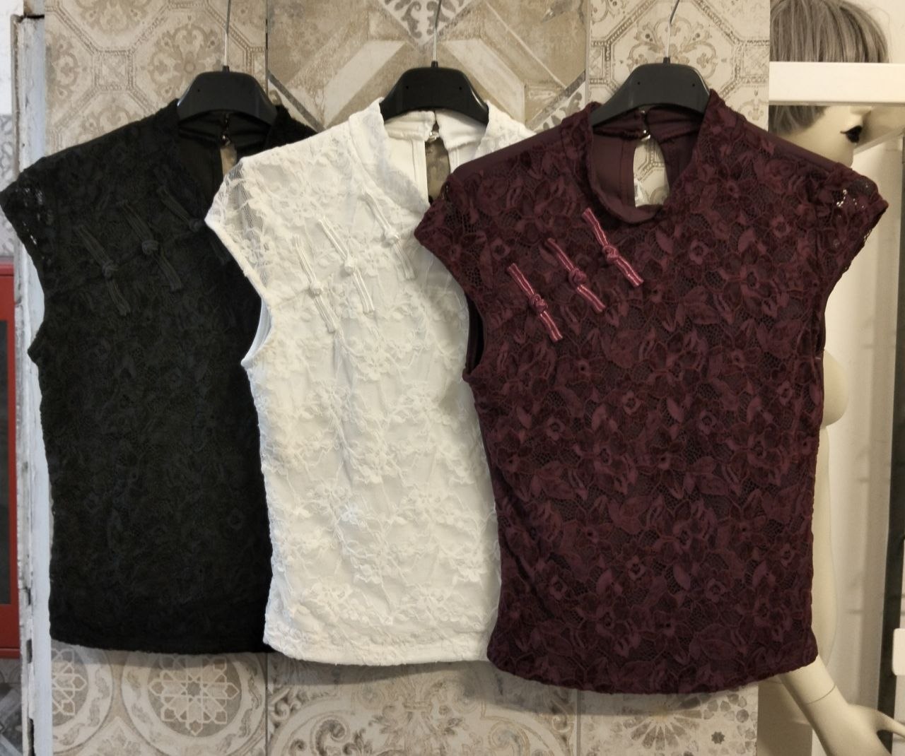 Top in pizzo con collo alla coreana e chiusure decorative frontali